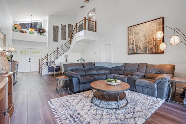 living room featuring hardwood / wood-style floors, high vaulted ceiling, and french doors