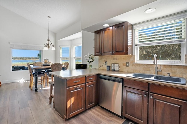 kitchen featuring dishwasher, sink, hanging light fixtures, vaulted ceiling, and kitchen peninsula