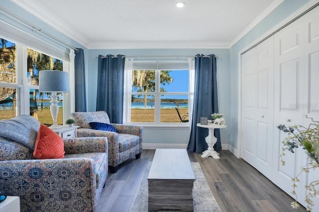 living area with ornamental molding, plenty of natural light, and dark wood-type flooring