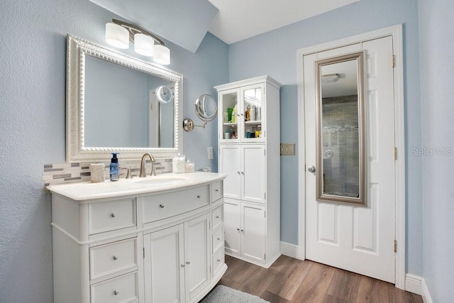 bathroom with decorative backsplash, vanity, and hardwood / wood-style flooring