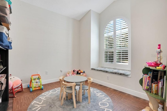 recreation room with dark hardwood / wood-style flooring and lofted ceiling