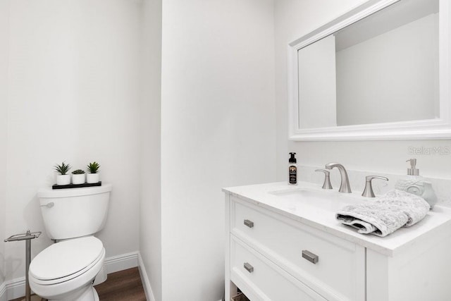 bathroom featuring wood-type flooring, vanity, and toilet