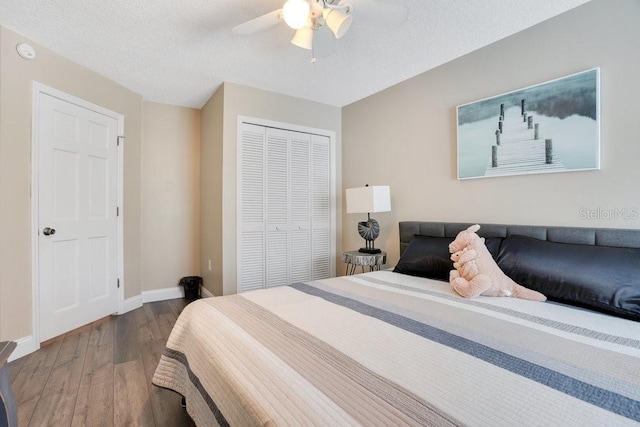 bedroom with dark hardwood / wood-style flooring, ceiling fan, a closet, and a textured ceiling