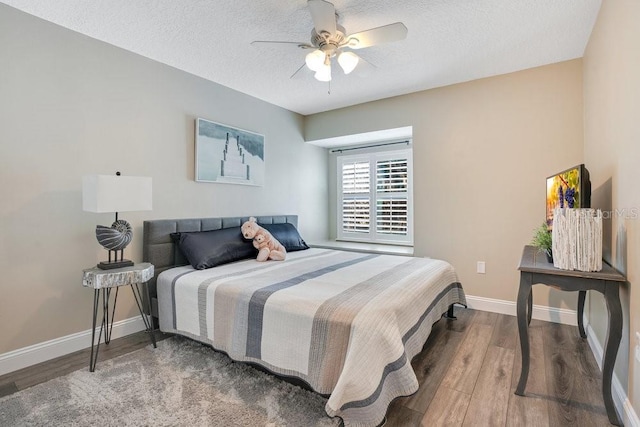 bedroom featuring hardwood / wood-style flooring, ceiling fan, and a textured ceiling