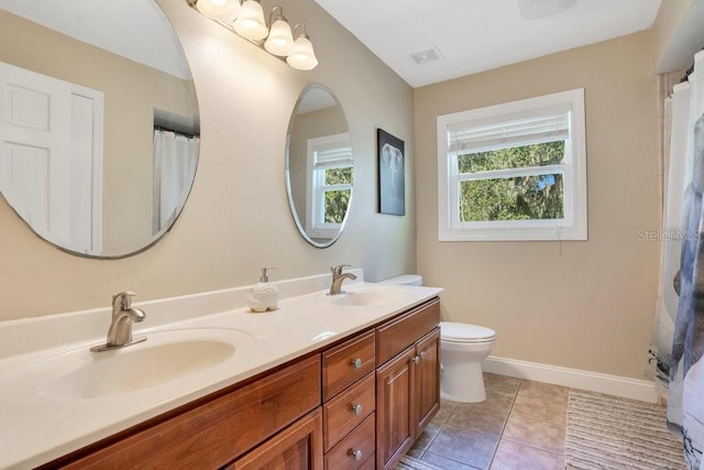 bathroom with tile patterned flooring, vanity, and toilet