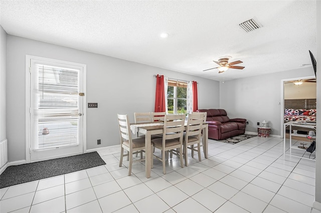 tiled dining area featuring ceiling fan and a textured ceiling