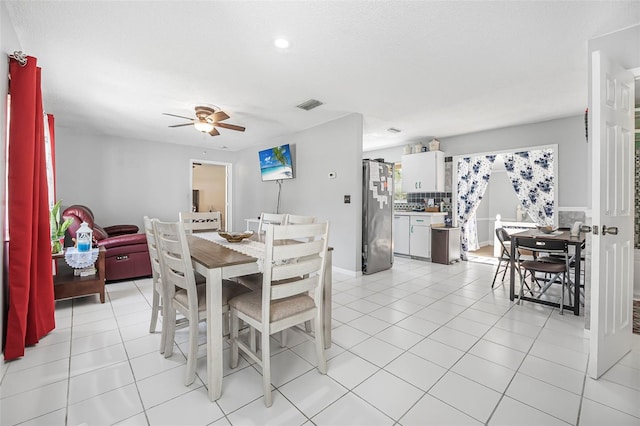 tiled dining area with ceiling fan