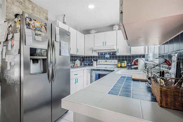 kitchen with white cabinets, white range with electric stovetop, stainless steel fridge, and sink