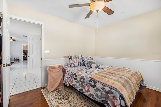 bedroom with dark hardwood / wood-style flooring and ceiling fan