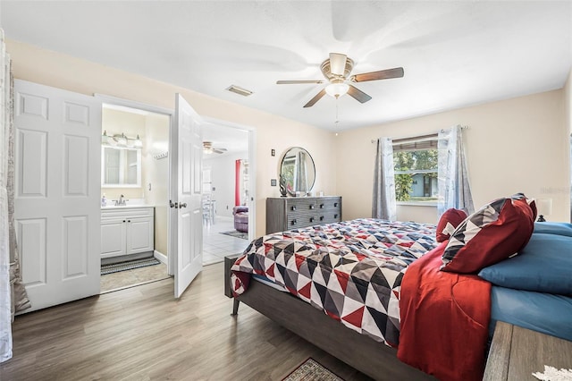 bedroom featuring ceiling fan, light wood-type flooring, and ensuite bath