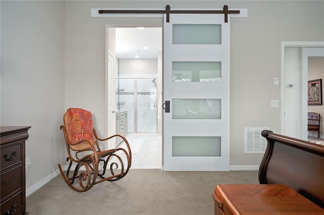 living area with a barn door and light colored carpet