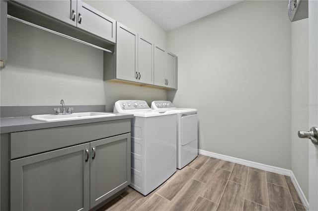 laundry room featuring washer and clothes dryer, cabinets, and sink