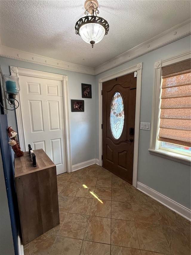 foyer with crown molding and a textured ceiling