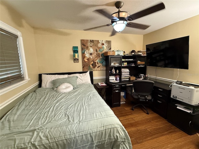 bedroom with ceiling fan and dark wood-type flooring