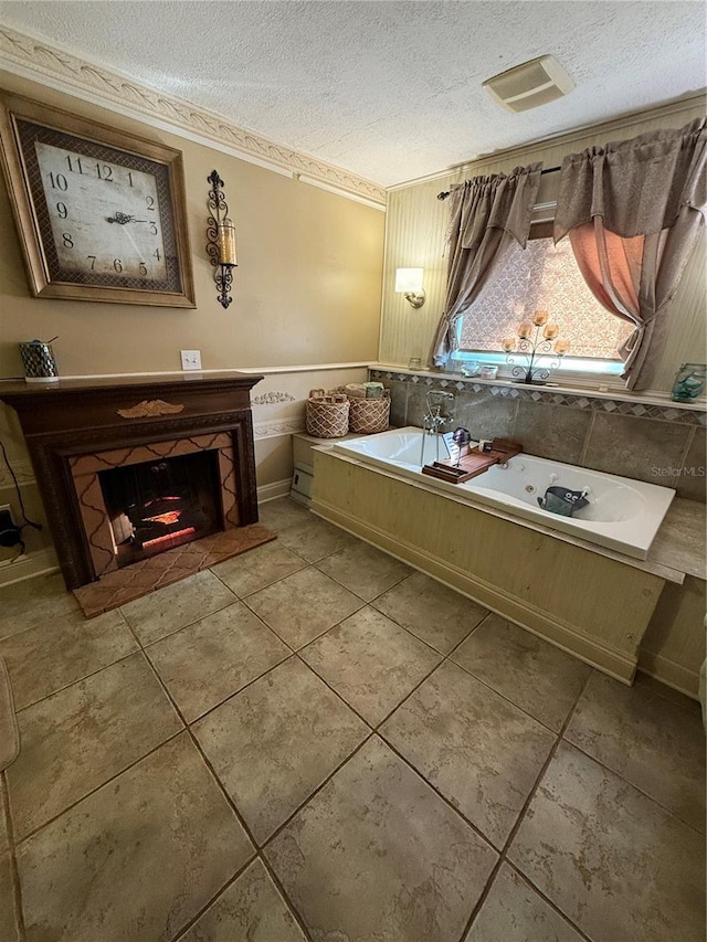 bathroom with tile patterned floors, a fireplace, a tub to relax in, and a textured ceiling