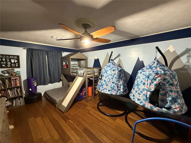 bedroom with wood-type flooring, a textured ceiling, and ceiling fan