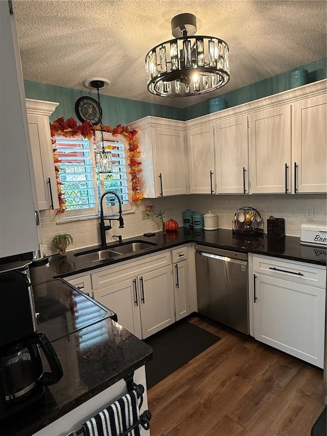 kitchen featuring white cabinetry, dishwasher, sink, and hanging light fixtures