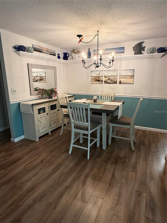 dining area with a notable chandelier, a textured ceiling, and dark hardwood / wood-style flooring