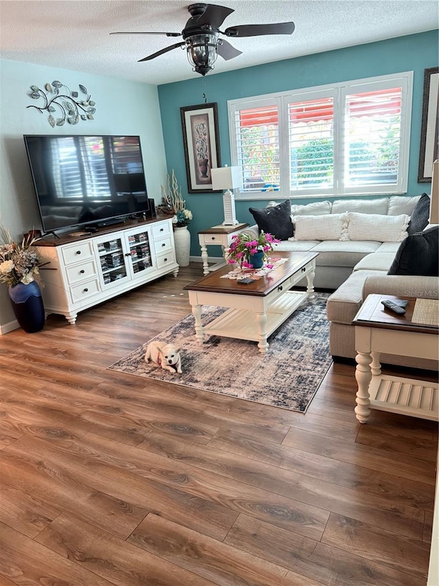 living room with ceiling fan, dark hardwood / wood-style floors, and a textured ceiling