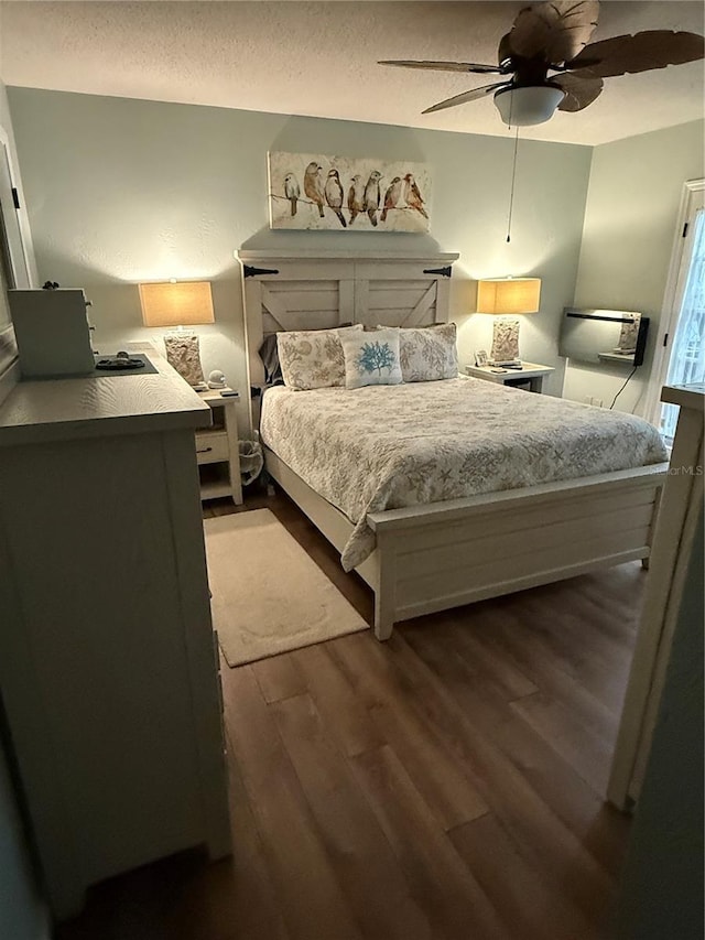 bedroom featuring ceiling fan, hardwood / wood-style floors, and a textured ceiling