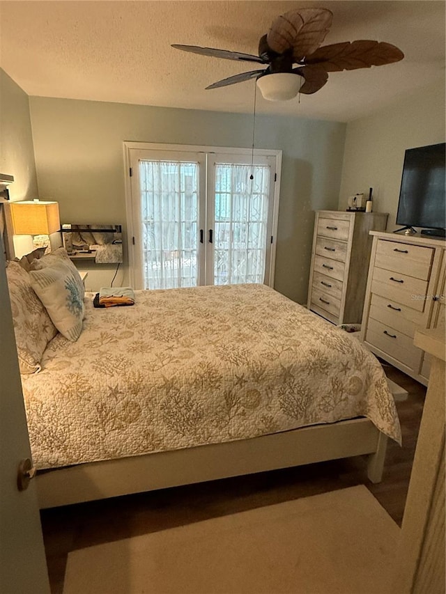 bedroom with ceiling fan, access to exterior, and a textured ceiling