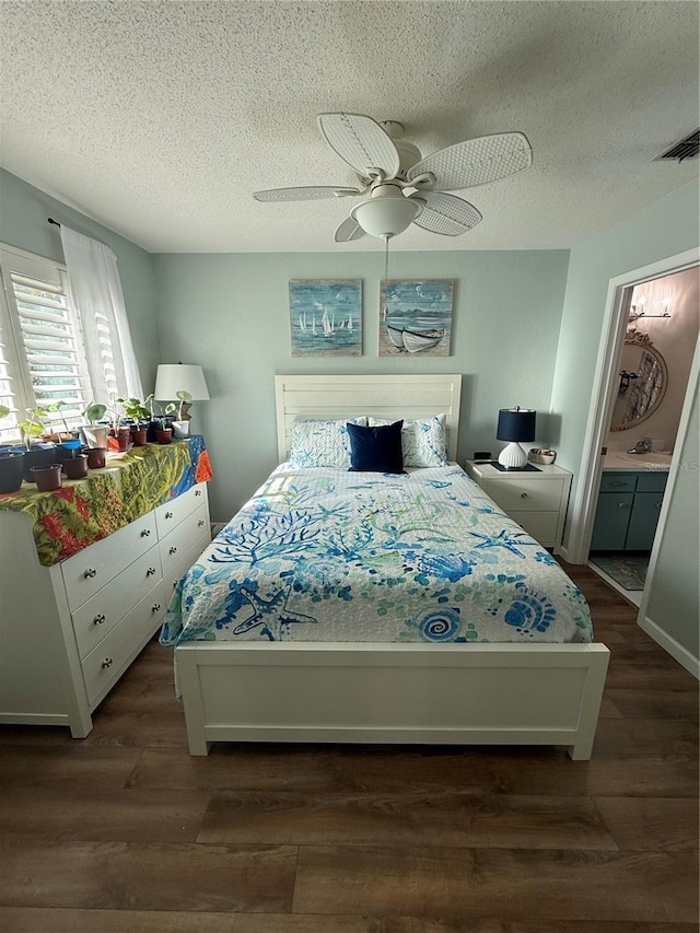 bedroom featuring sink, ceiling fan, dark hardwood / wood-style floors, connected bathroom, and a textured ceiling