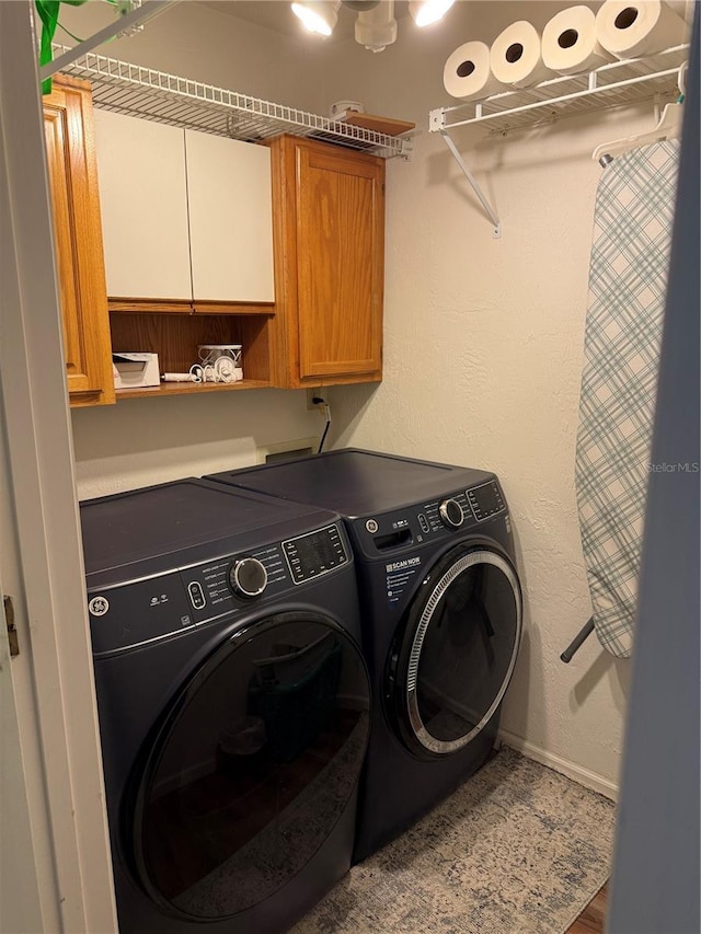 laundry area with cabinets and washer and clothes dryer