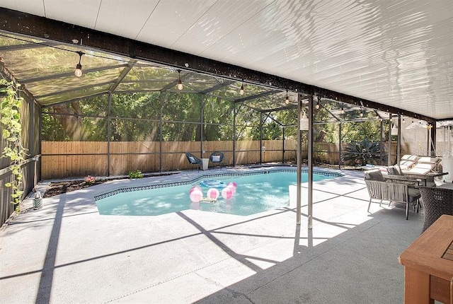 view of swimming pool featuring a lanai and a patio area