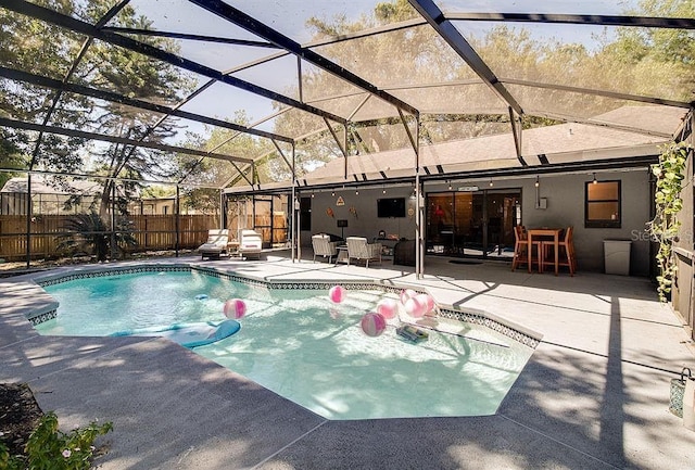 view of swimming pool featuring glass enclosure and a patio