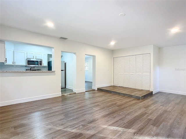 unfurnished living room with wood-type flooring