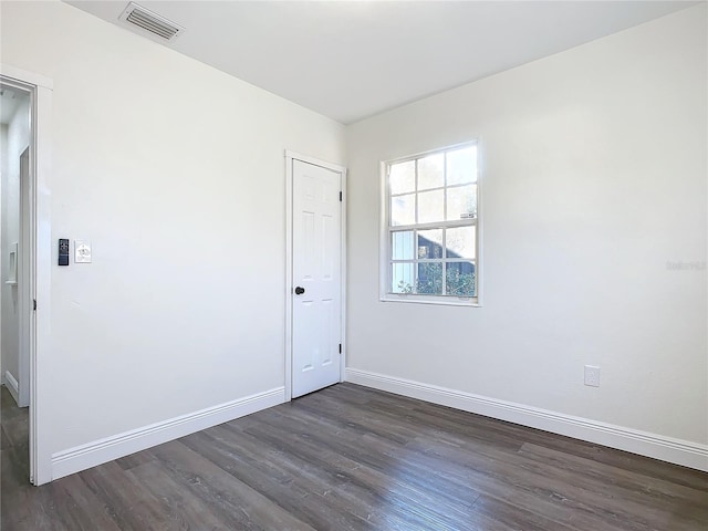 unfurnished room featuring dark wood-type flooring