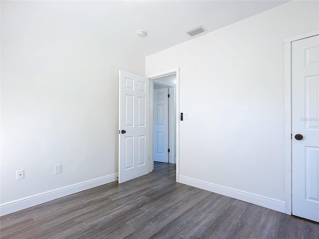 unfurnished room with dark wood-type flooring