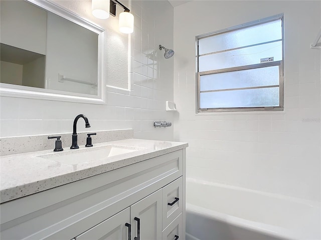 bathroom featuring tasteful backsplash, vanity, and tiled shower / bath combo