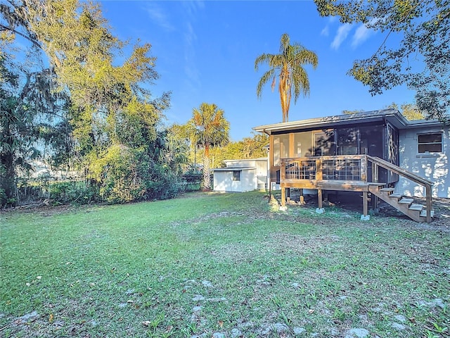 view of yard featuring a sunroom and a storage unit