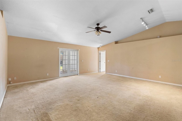 spare room featuring track lighting, ceiling fan, lofted ceiling, and light colored carpet