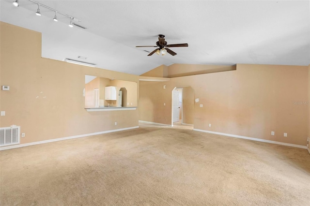 unfurnished living room featuring rail lighting, light colored carpet, ceiling fan, and lofted ceiling