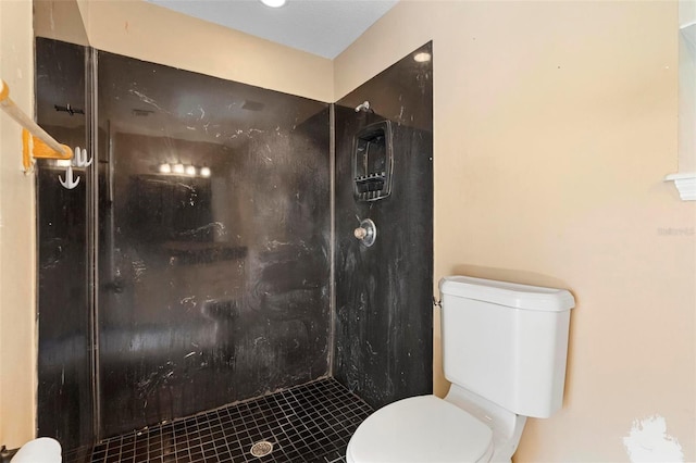 bathroom featuring tiled shower and toilet