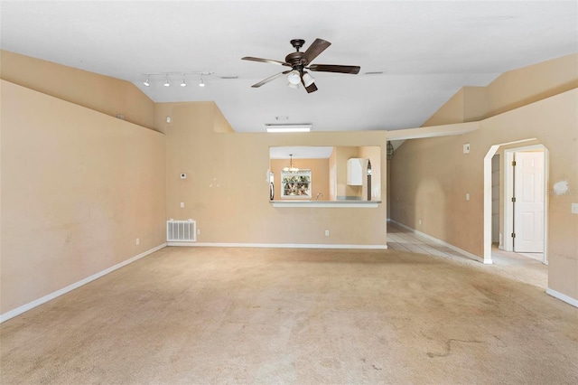 carpeted empty room featuring ceiling fan, rail lighting, and vaulted ceiling