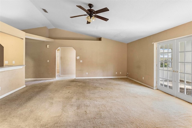 empty room with ceiling fan, light colored carpet, lofted ceiling, and french doors