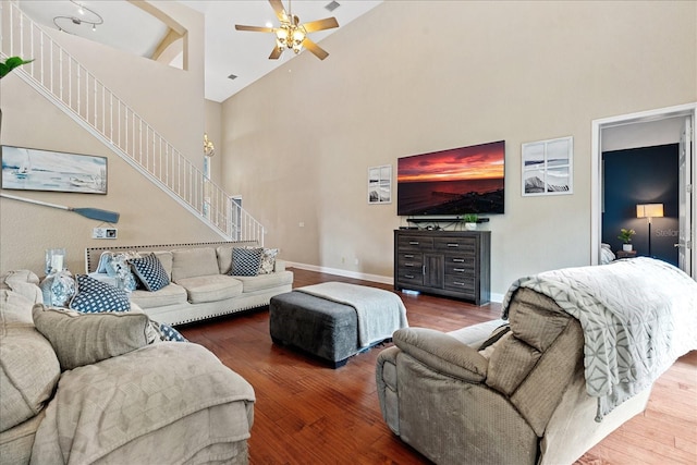 living room with hardwood / wood-style flooring, ceiling fan, and high vaulted ceiling