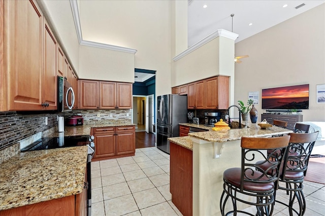 kitchen featuring light stone countertops, stainless steel appliances, kitchen peninsula, a breakfast bar, and light tile patterned flooring