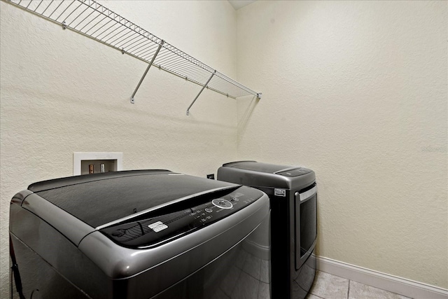 laundry area featuring washer and dryer and light tile patterned flooring