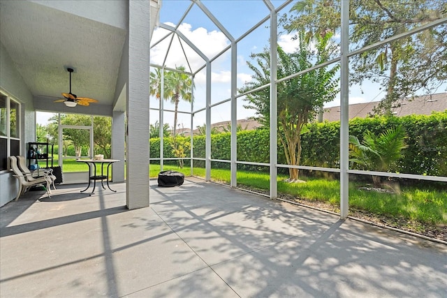 unfurnished sunroom featuring a wealth of natural light and ceiling fan