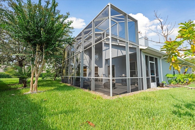 back of house with a lanai, a patio area, and a yard