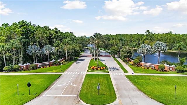 view of home's community with a water view and a yard