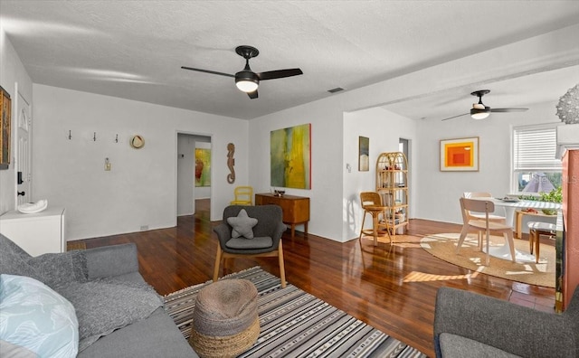 living room with hardwood / wood-style floors, ceiling fan, and a textured ceiling