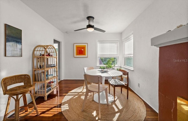 dining area with ceiling fan and dark wood-type flooring