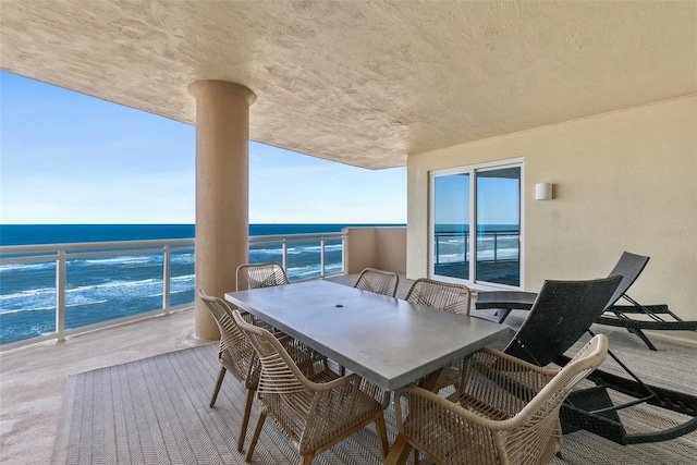 balcony featuring a view of the beach and a water view