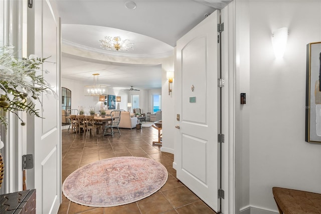 tiled foyer entrance featuring ceiling fan with notable chandelier