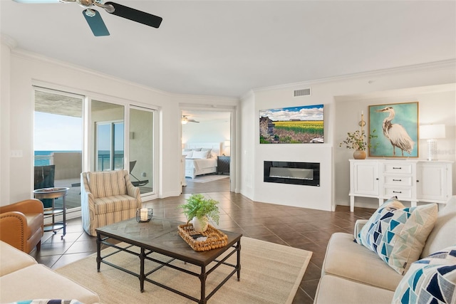 living room with tile patterned floors, ceiling fan, and ornamental molding